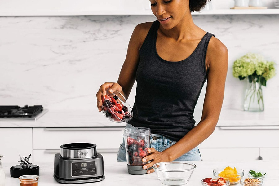 Image of a woman holding a Shark Ninja blender. The image illustrates the SharkNinja case study that presents the results that Stars and Stories has brought to the company through authentic ratings and reviews.