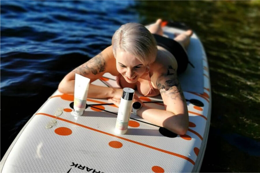 Image of a woman, lying on a board in the water, enjoys Wella products. It represents the success of the partnership between Wella and Stars and stories in their authentic buzz campaign.